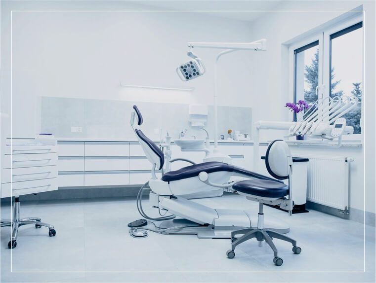 A dentist 's office with a chair and desk.