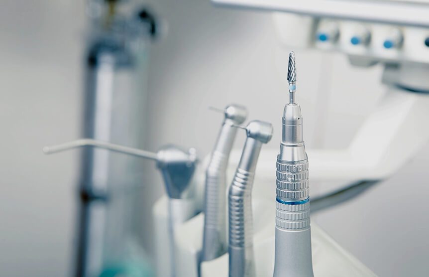 A group of dental instruments sitting on top of a counter.